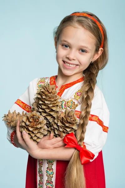 Девушка в русский народный костюм, холдинг Шишки кедровые — стоковое фото