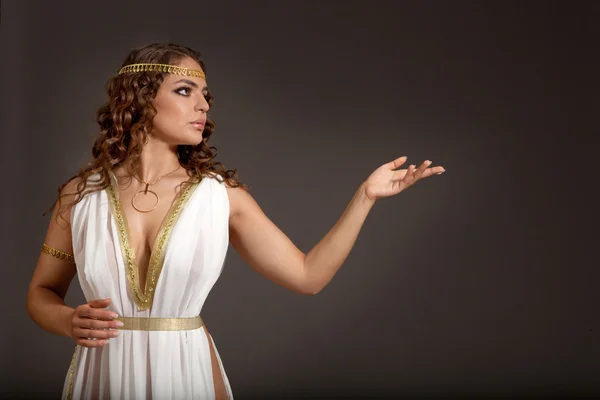 Классическая греческая богиня в тунике, показывая что-то — стоковое фото