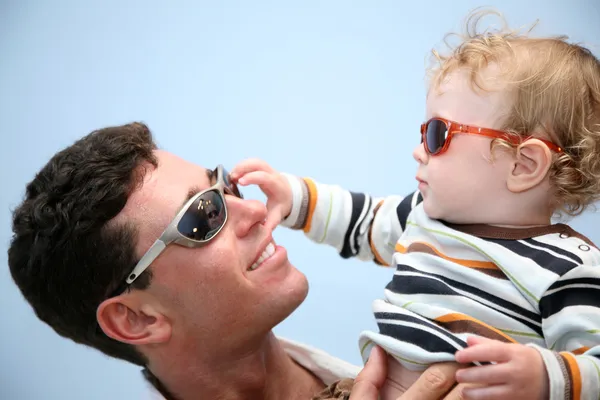 Отец с ребенком в солнцезащитные очки на фоне неба — стоковое фото